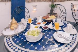 une table bleue et blanche avec de la nourriture dans l'établissement Riad Dar Nawfal, à Sale