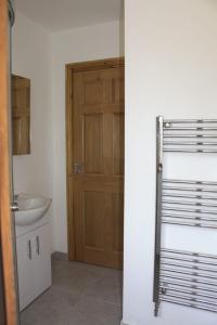 a bathroom with a wooden door and a sink at Butterfly cabin in Limerick
