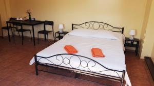 a bedroom with a bed with two orange towels on it at Pokoje Gościnne Relaks in Gdynia