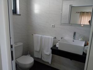 a bathroom with a white toilet and a sink at Casa da Bella in Velas +60 photos