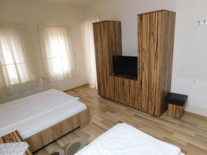 a room with two beds and a flat screen tv at Pensiunea Agroturistica Havanna in Zalău