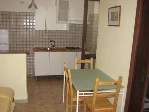 cocina y comedor con mesa y sillas en Elios Residence Hotel, en Sapri