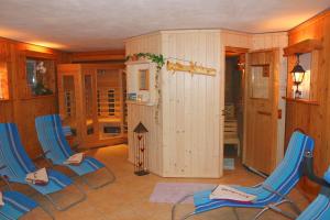 Pokój z 2 niebieskimi krzesłami i lodówką w obiekcie Gästehaus Oberauer w mieście Annaberg im Lammertal