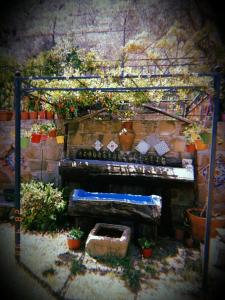 een piano in een tuin met potplanten bij L'Uliveto in Reitano