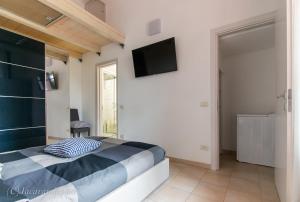 een slaapkamer met een bed en een tv aan de muur bij La Suite di Bonnes Vacances in Pietrasanta