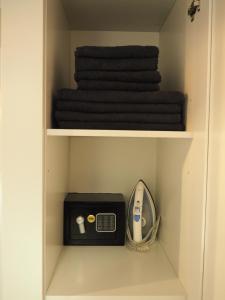 a cupboard with a scale and a alarm clock and towels at Apartament Alicja in Sztutowo