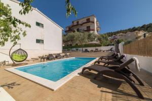 einen Pool mit Liegestühlen neben einem Gebäude in der Unterkunft Villa Calluna in Trogir