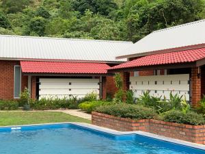 uma casa com uma piscina em frente em Hujung Kampung Estate em Pantai Cenang