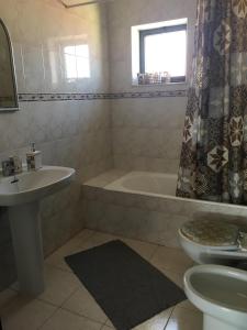 een badkamer met een wastafel, een bad en een toilet bij Mira House in Praia de Mira