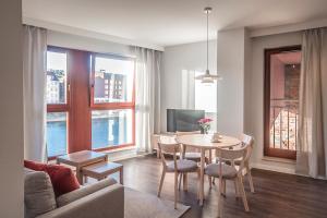 a living room with a table and chairs and a couch at EGH Waterlane Island Apartment in Gdańsk