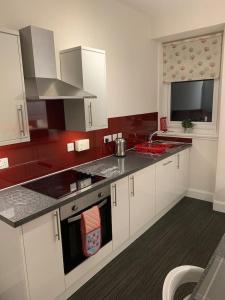 a kitchen with white cabinets and a counter top at Apartment 39c in Oban