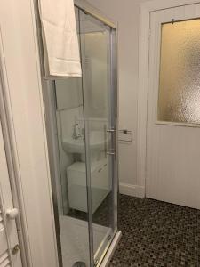 a glass shower in a bathroom with a sink at Apartment 39c in Oban