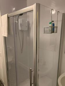a shower with a glass door in a bathroom at Apartment 39c in Oban