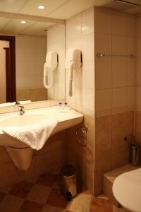 uma casa de banho com um lavatório, um WC e um espelho. em Hotel Yunona - All Inclusive em Sunny Beach