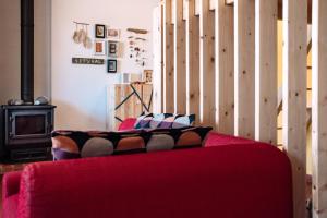 a red couch in a room with a wooden wall at PEDRA DOS CORVOS Beach House in Odeceixe