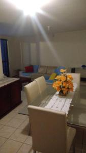 - un salon avec une table et un vase de fleurs dans l'établissement Apto-beiramar-completo-3 qt- até 9 pes-TV-WiFi-gar, à Fortaleza