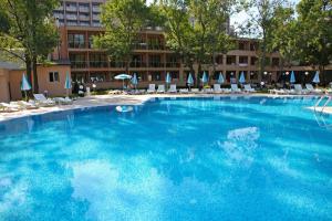 una grande piscina blu con sedie e ombrelloni di Hotel Yunona - All Inclusive a Sunny Beach