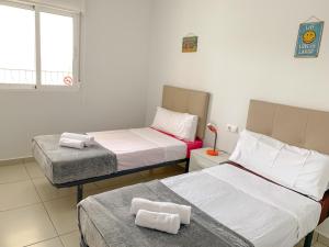 una habitación con dos camas y una ventana en Residencial El Pinet Beach, en La Marina