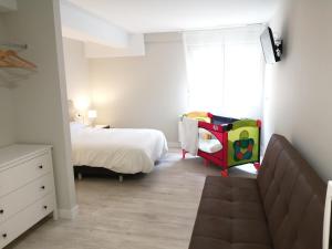 um pequeno quarto com uma cama e um berço para crianças em Estudios los Arcos em Teruel