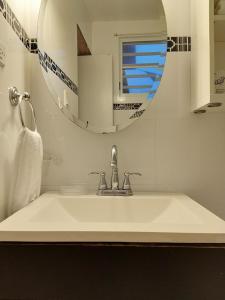 a bathroom with a sink and a mirror at La Capitana Old San Juan Building in San Juan