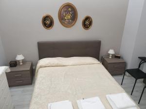 a bedroom with a large bed with two tables and two mirrors at Matteotti Apartment in Rapallo