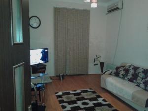 a living room with a couch and a tv at Apartment Niyazi 5 in Baku