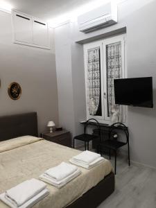 a bedroom with two beds and a flat screen tv at Matteotti Apartment in Rapallo