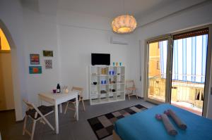 1 dormitorio con cama, mesa y TV en Casa Maja, en Giardini Naxos
