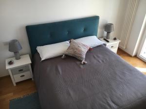 1 cama con cabecero azul y 2 mesitas de noche en Teti Holiday Home, en Polignano a Mare