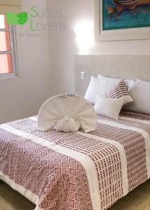 a bed with a blanket on top of it at Suites Lorens in Isla Mujeres