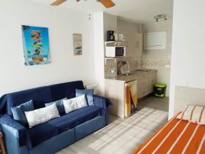 a living room with a blue couch and a kitchen at Benalmadena Aguila apartment wonderful views in Benalmádena