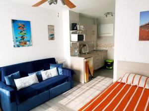 a living room with a blue couch and a kitchen at Benalmadena Aguila apartment wonderful views in Benalmádena