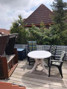 une table et deux chaises sur une terrasse avec une table et des chaises dans l'établissement Strandroggen, à Wangerland