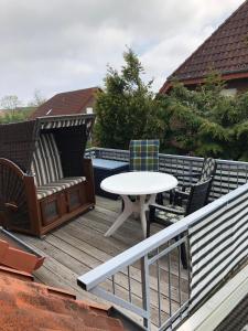 eine Terrasse mit Tisch und Stühlen auf einem Deck in der Unterkunft Strandroggen in Wangerland