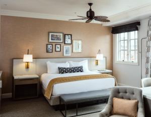 a bedroom with a large bed and a chair at La Valencia Hotel in San Diego +36 photos