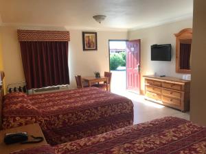 a hotel room with two beds and a television at El Rancho Dolores at JT National Park in Twentynine Palms