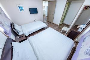 a hospital room with two beds and a tv at Tamragio Residence Hotel in Jeju