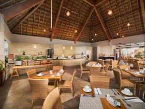 a restaurant with wooden tables and chairs and a counter at El Cid La Ceiba Beach in Cozumel