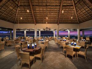 a restaurant at the beach with tables and chairs at El Cid La Ceiba Beach in Cozumel