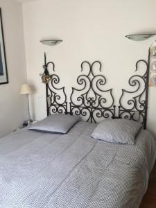 a bedroom with a bed with a metal headboard at Annie chambres hôtes in Cassagnabère-Tournas