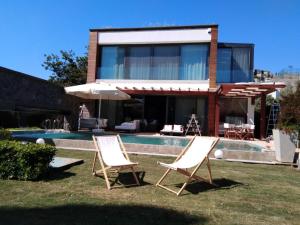 博德魯姆的住宿－Villa No 5，两把草坪椅和一把伞在房子前面