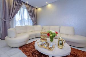 Arabella Residence في القاهرة: غرفة معيشة مع أريكة بيضاء وطاولة