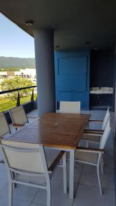 a wooden table and white chairs on a patio at Elegante departamento 2D in Yerba Buena