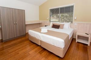 Un dormitorio con una cama grande y una ventana en BIG4 Sawtell Beach Holiday Park, en Sawtell