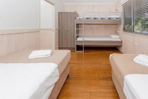 a room with two beds and a bunk bed at BIG4 Sawtell Beach Holiday Park in Sawtell