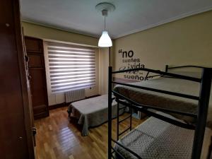 ein Zimmer mit zwei Etagenbetten und einem Fenster in der Unterkunft Apartamentos Avenida de la paz 2 in Logroño