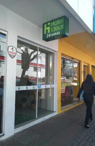 a woman walking in front of a hotel local hours at Hotel Ideal in Chapecó
