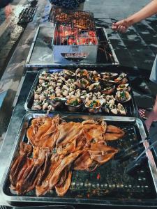 a group of trays of food on a grill at I Love Coto Hai Au Hotel is central near beach in Đảo Cô Tô