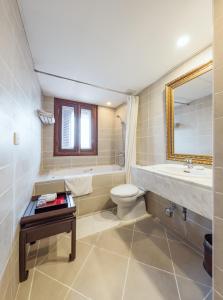 a bathroom with a sink toilet and a mirror at La Dolce Vita Hotel in Hanoi