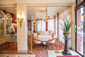 une salle à manger avec une table et des chaises blanches dans l'établissement Best Western Beauséjour, à Lourdes